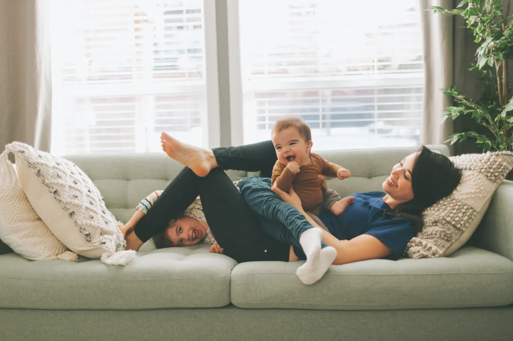 happy mother and children playing at home under a warm, cozy roof