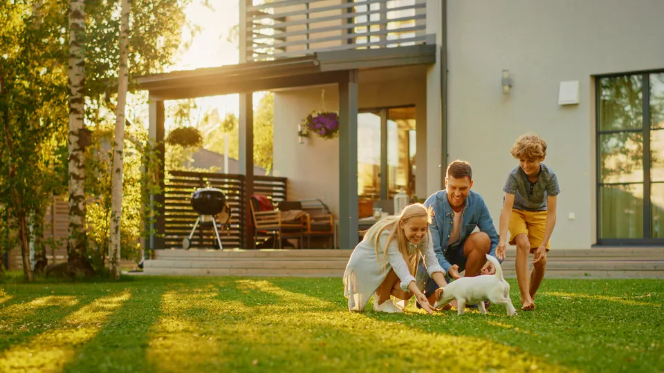 Happy family sitting outside together with their dog in Maple Grove