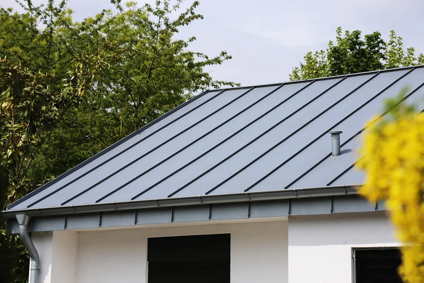dark metal roofing material on white house northface construction