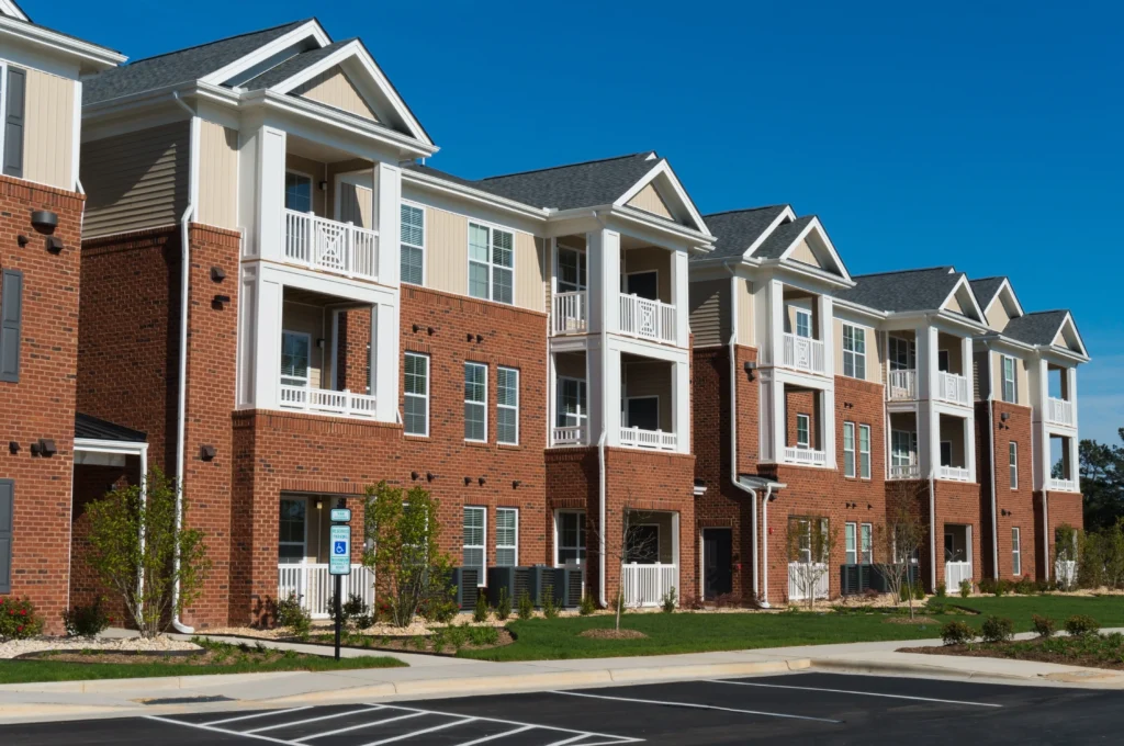 Tan and red condos overlooking a parking lot. condo roof replacement cost