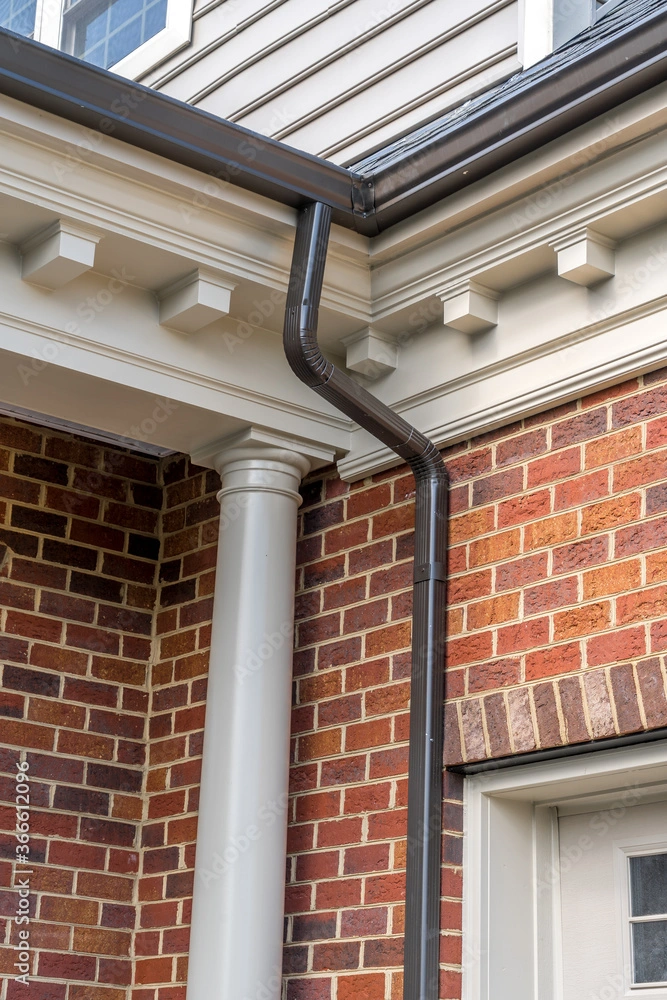 charcoal grey gutters on a brick house