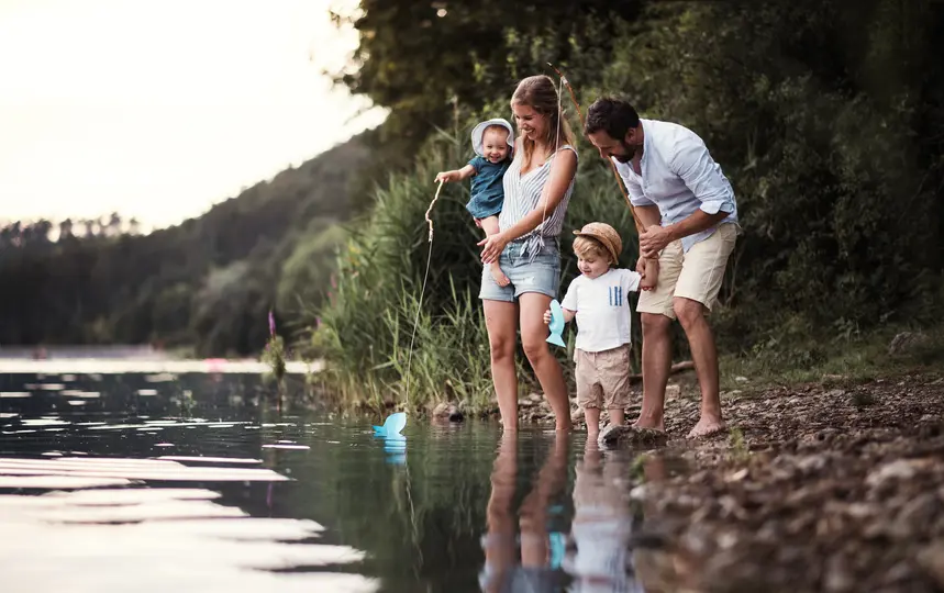 Young happy family enjoys time by lake in excelsior mn
