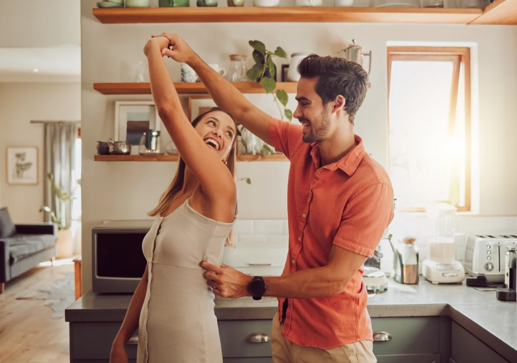 Happy young homeowners dance in the kitchen of their edina home