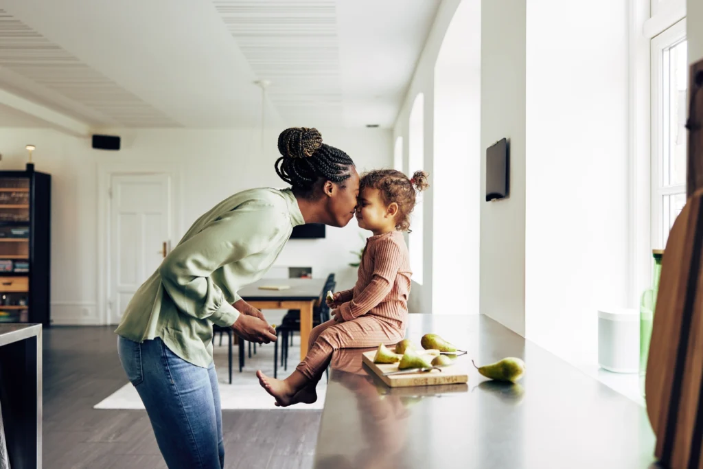 Happy mother and daughter in kitchen in Zimmerman home