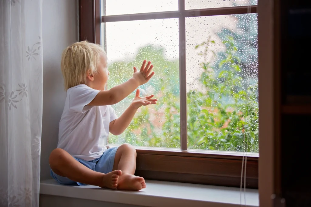 young child looks out the window in minnesota home
