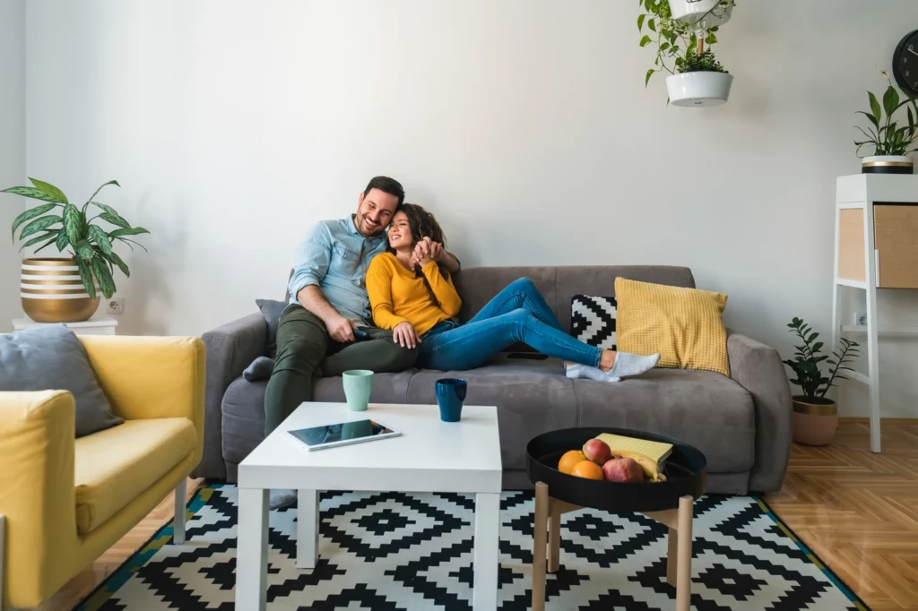 Happy young couple lounges on couch in their edina home