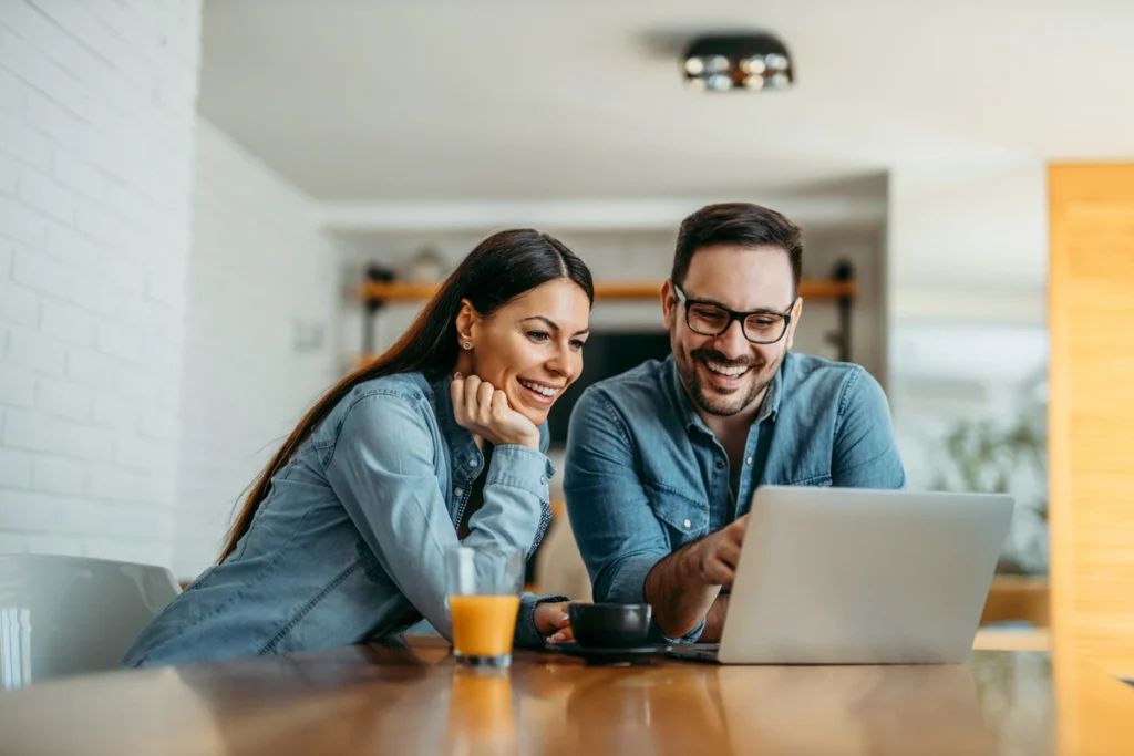 smiling couple looking at computer