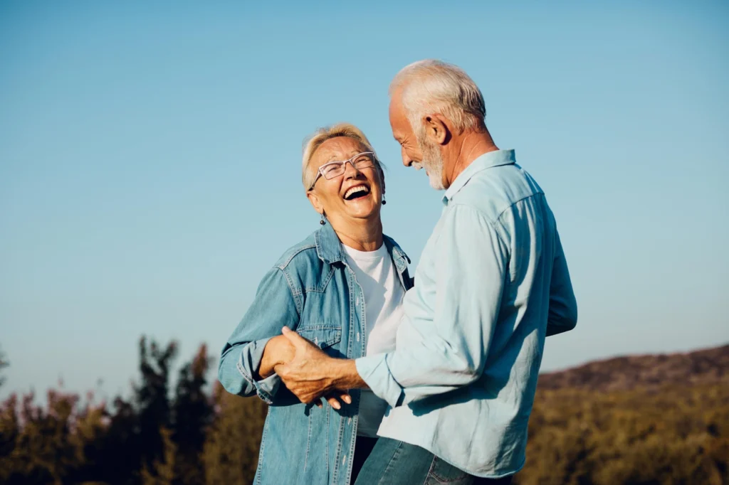 an older man and woman embrace and laugh outside in Minnetonka MN