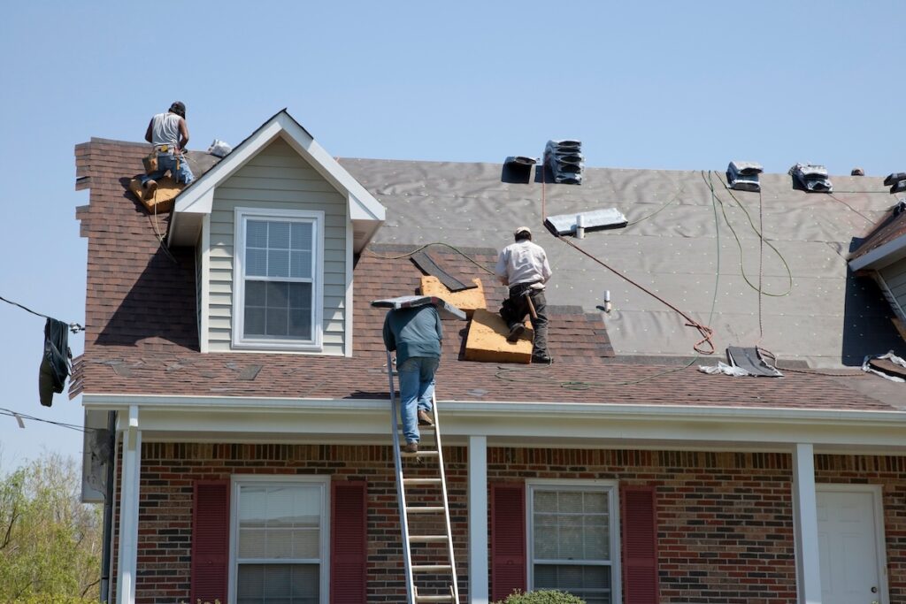 Roofers replacing damaged shingles
