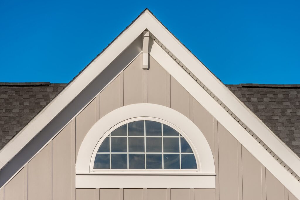 Gable roof with tan siding and window