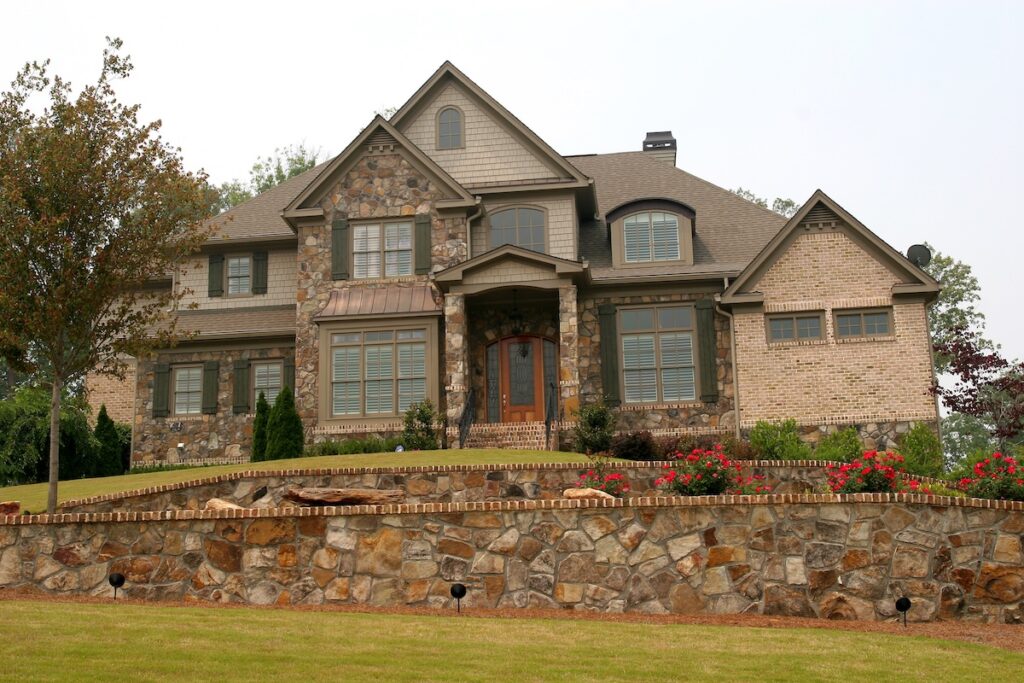 A nice house on a hill over a stone wall