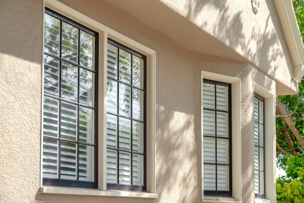 Windows of a house with beige rough concrete walls