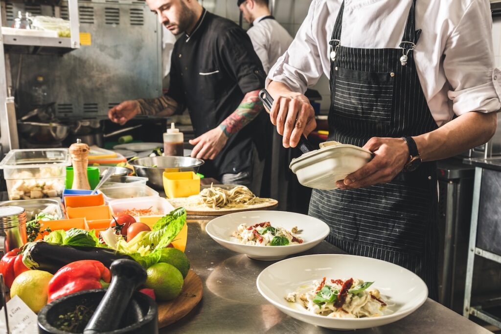 Professional chef cooking in the kitchen restaurant, preparing dinner.